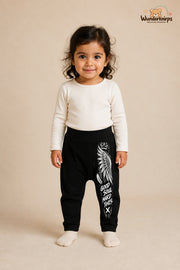 Engelsflügel Lieblingslook – Good soul hard times – Babyhose für Mädchen: Schwarz mit Engelsflügel-Druck am Hosenbein – Wunderknirps.