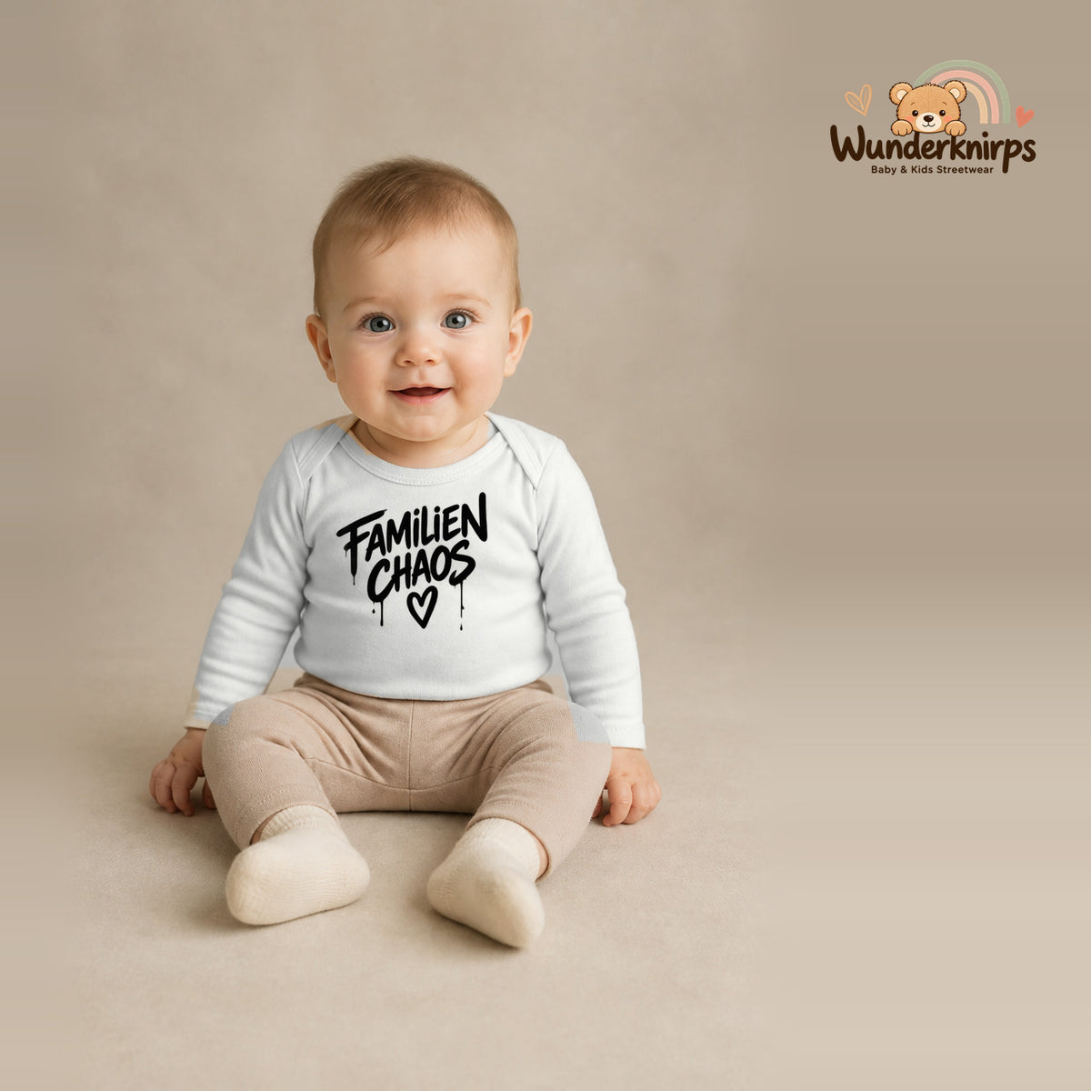 Babybody für Jungen in Weiß mit Motiv „Familienchaos“, getragen von einem Kind – Wunderknirps.
