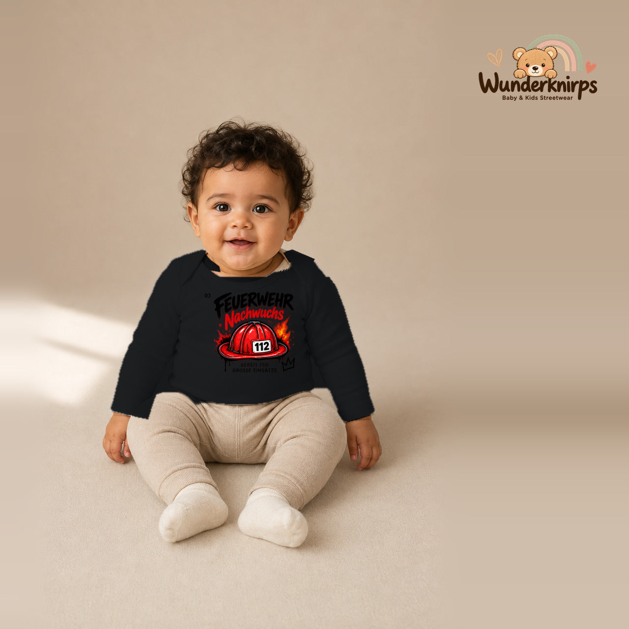 Babybody für Jungen in Schwarz mit Motiv „Feuerwehr Nachwuchs“, getragen von einem Kind – Wunderknirps.