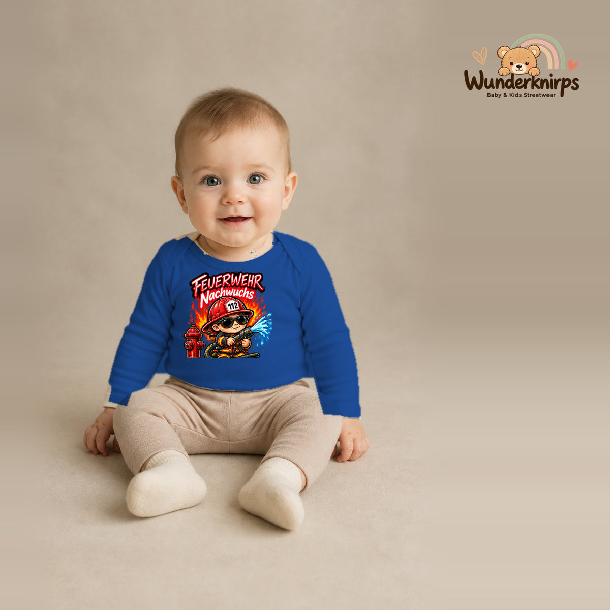 Babybody für Jungen in Blau mit Motiv „Feuerwehr Nachwuchs“, getragen von einem Kind – Wunderknirps.