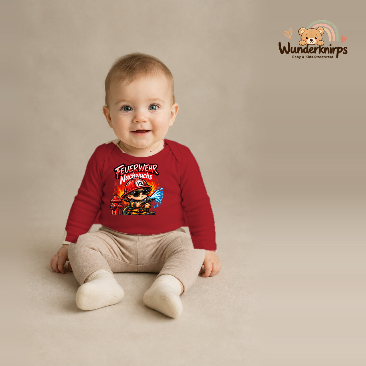 Babybody für Jungen in Rot mit Motiv „Feuerwehr Nachwuchs“, getragen von einem Kind – Wunderknirps.