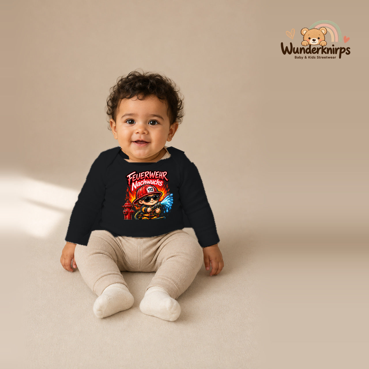 Babybody für Jungen in Schwarz mit Motiv „Feuerwehr Nachwuchs“, getragen von einem Kind – Wunderknirps.