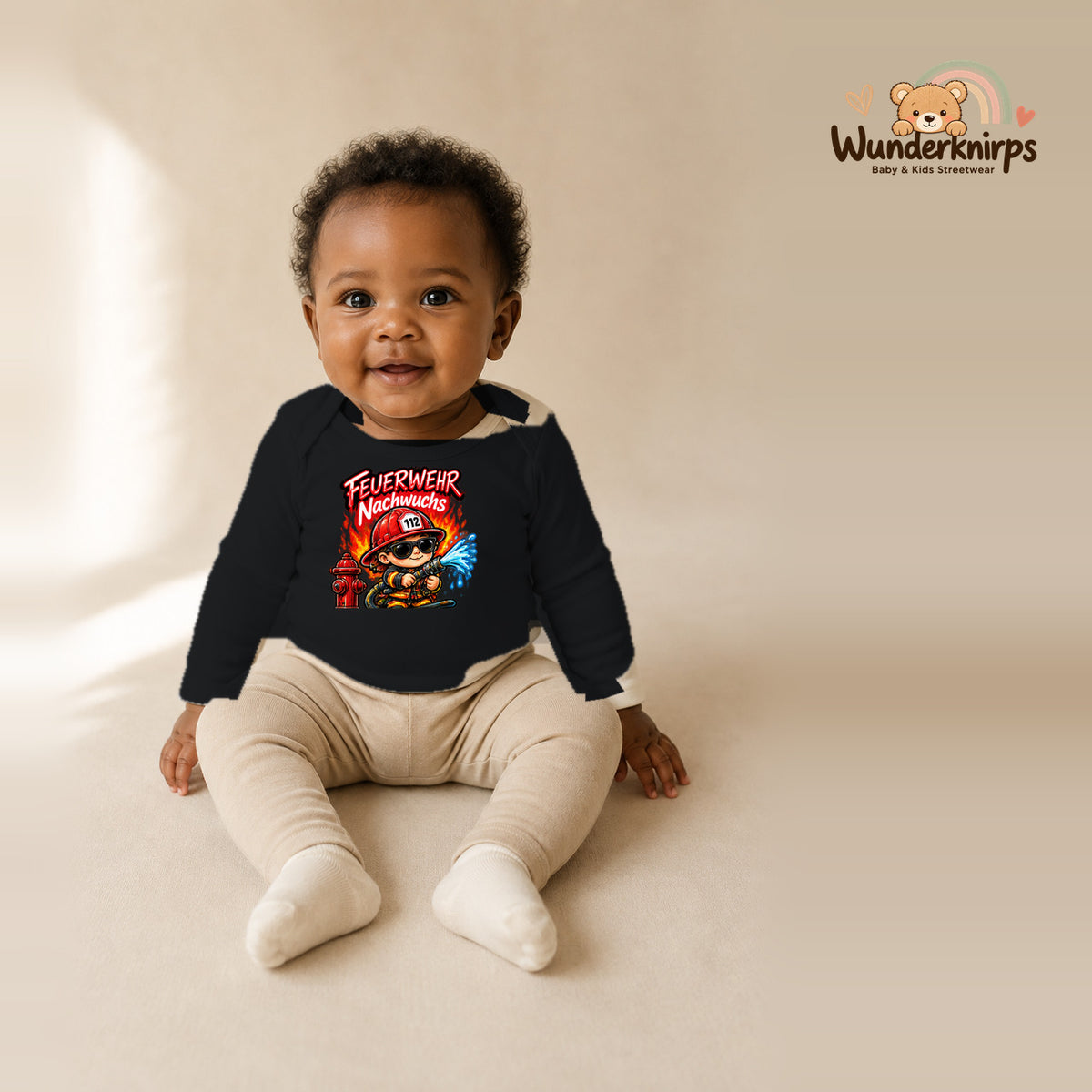 Babybody für Mädchen in Schwarz mit Motiv „Feuerwehr Nachwuchs“, getragen von einem Kind – Wunderknirps.