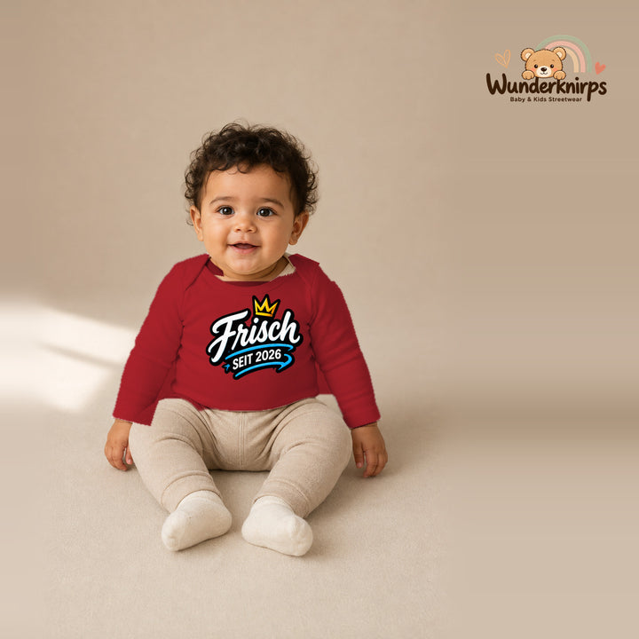 Babybody für Jungen in Rot mit Motiv „Frisch seit 2026“, getragen von einem Kind – Wunderknirps.
