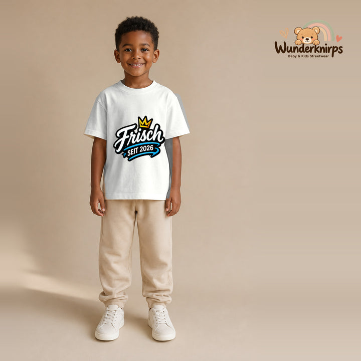 T-Shirt für Jungen in Weiß mit Motiv „Frisch seit 2026“, getragen von einem Kind – Wunderknirps.