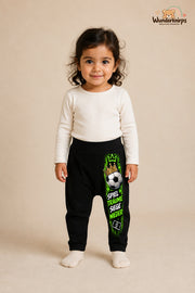 Fußball Lieblingslook – Spiel Träume siege wieder – Babyhose für Mädchen: Schwarz mit Fußball-Druck am Hosenbein – Wunderknirps.