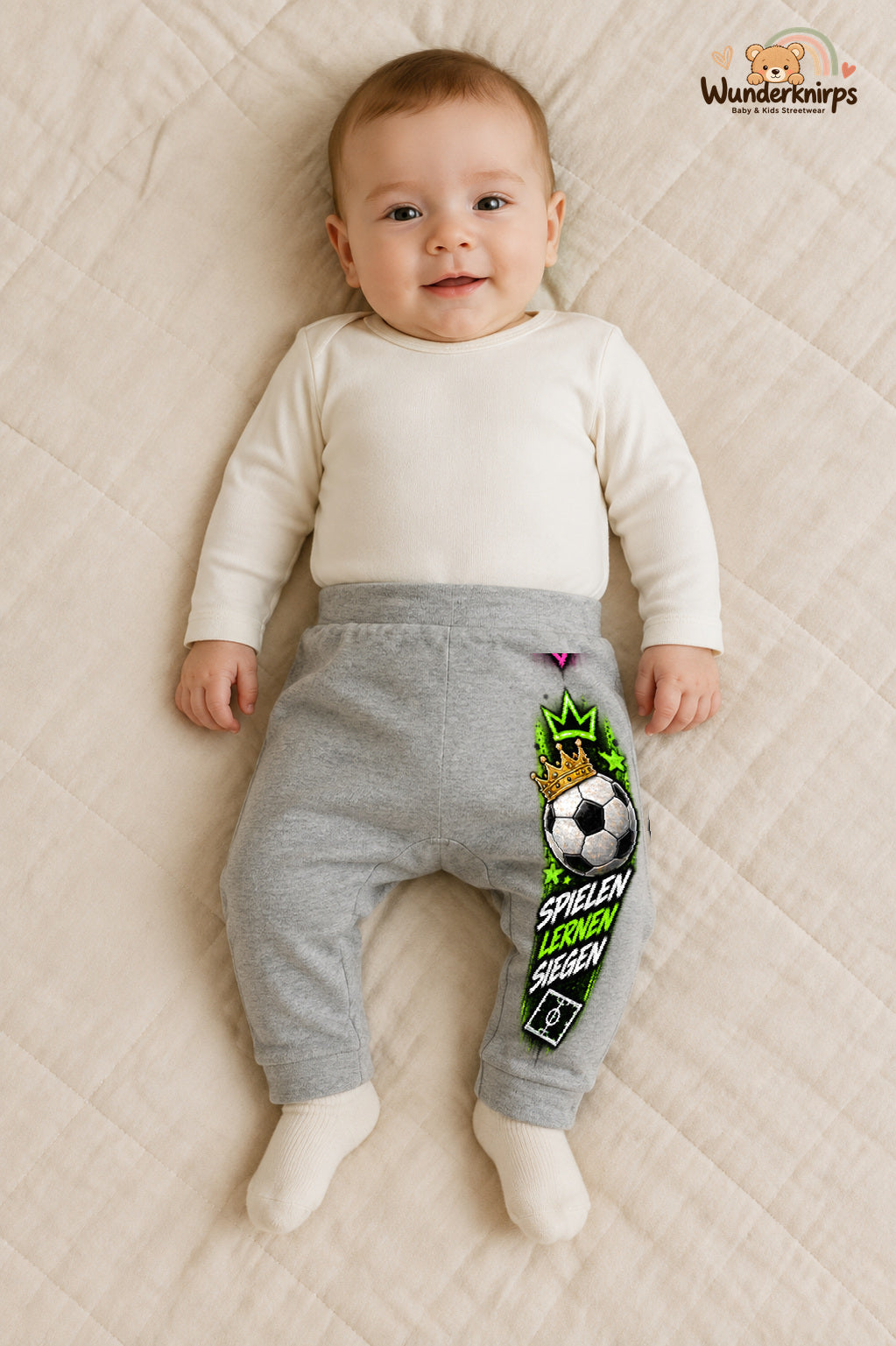 Spielen lernen siegen – Babyhose mit dem Motiv Fußball – für Jungen: Grau meliert mit Fußball-Druck am Hosenbein – Wunderknirps.