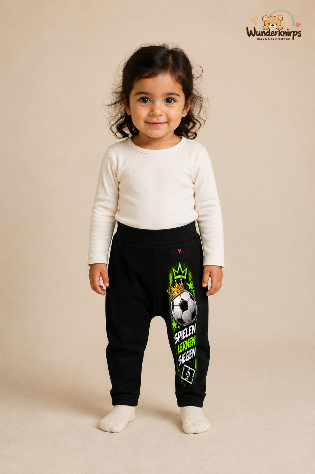 Fußball Lieblingslook – Spielen lernen siegen – Babyhose für Mädchen: Schwarz mit Fußball-Druck am Hosenbein – Wunderknirps.