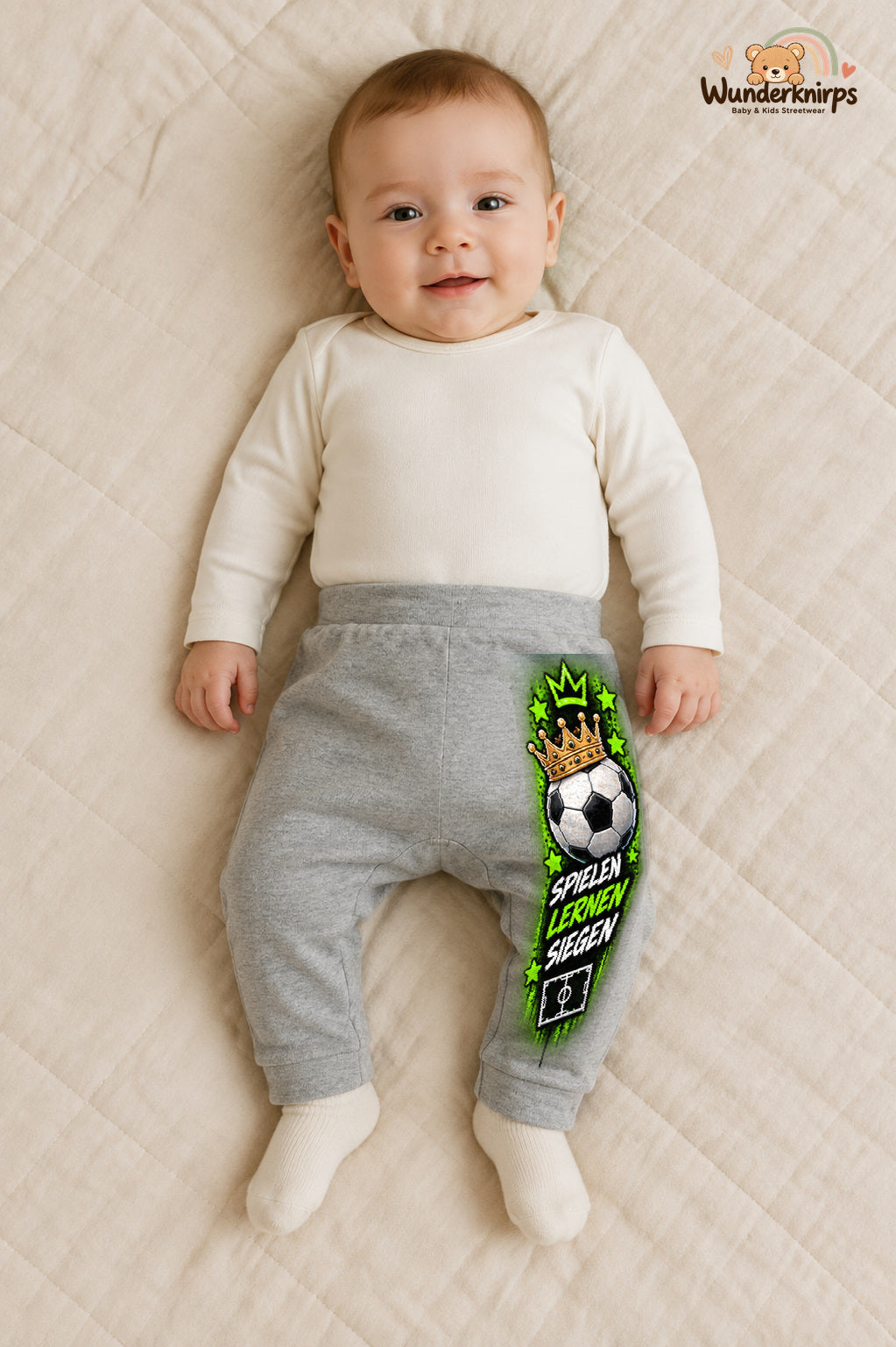 Fußball Alltagsheld – Spielen lernen siegen – Babyhose für Jungen: Grau meliert mit Fußball-Druck am Hosenbein – Wunderknirps.