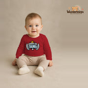 Babybody für Jungen in Rot mit Motiv „Geboren zum Träumen“, getragen von einem Kind – Wunderknirps.