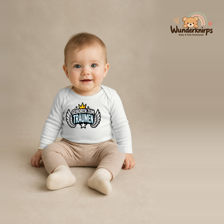 Babybody für Jungen in Weiß mit Motiv „Geboren zum Träumen“, getragen von einem Kind – Wunderknirps.