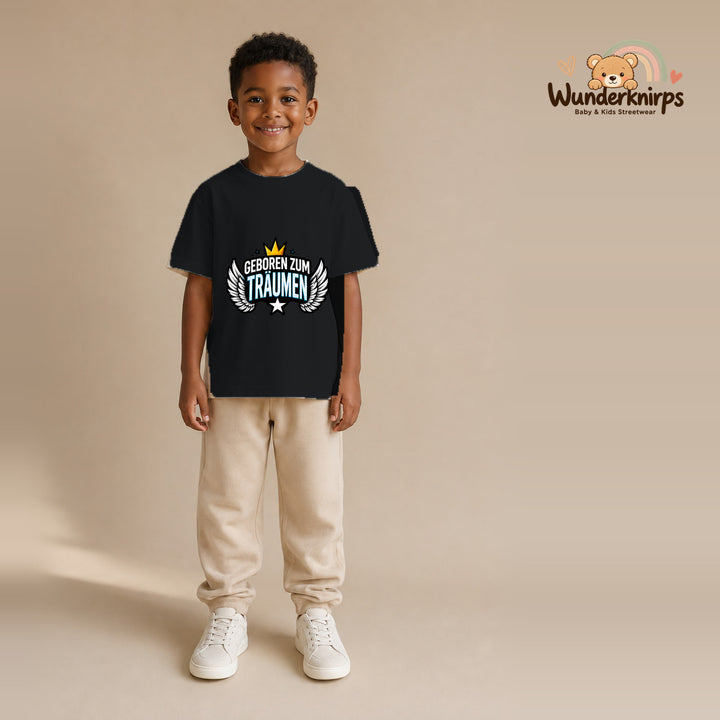 T-Shirt für Jungen in Schwarz mit Motiv „Geboren zum Träumen“, getragen von einem Kind – Wunderknirps.
