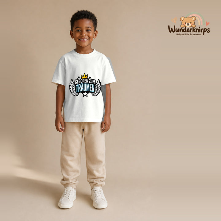 T-Shirt für Jungen in Weiß mit Motiv „Geboren zum Träumen“, getragen von einem Kind – Wunderknirps.