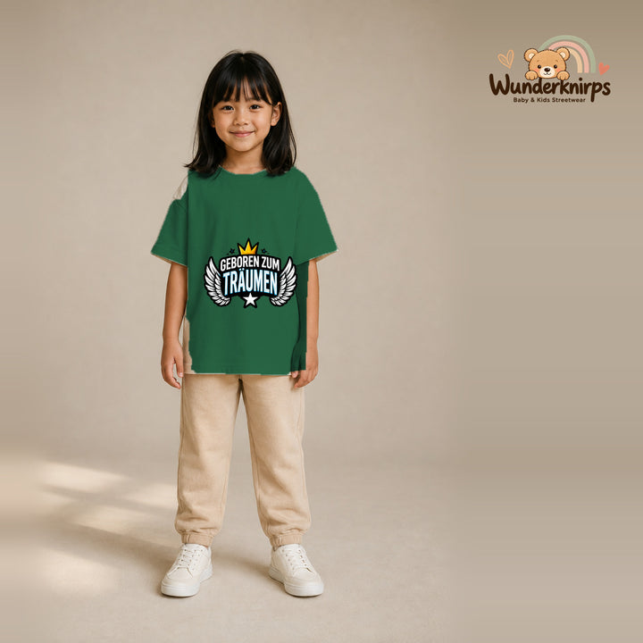 T-Shirt für Mädchen in Grün mit Motiv „Geboren zum Träumen“, getragen von einem Kind – Wunderknirps.