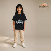 T-Shirt für Mädchen in Schwarz mit Motiv „Geboren zum Träumen“, getragen von einem Kind – Wunderknirps.