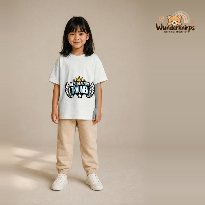 T-Shirt für Mädchen in Weiß mit Motiv „Geboren zum Träumen“, getragen von einem Kind – Wunderknirps.