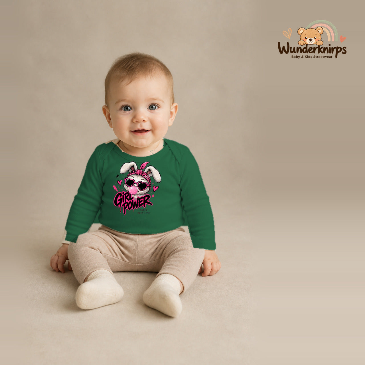 Babybody für Jungen in Grün mit Motiv „Girl Power“, getragen von einem Kind – Wunderknirps.