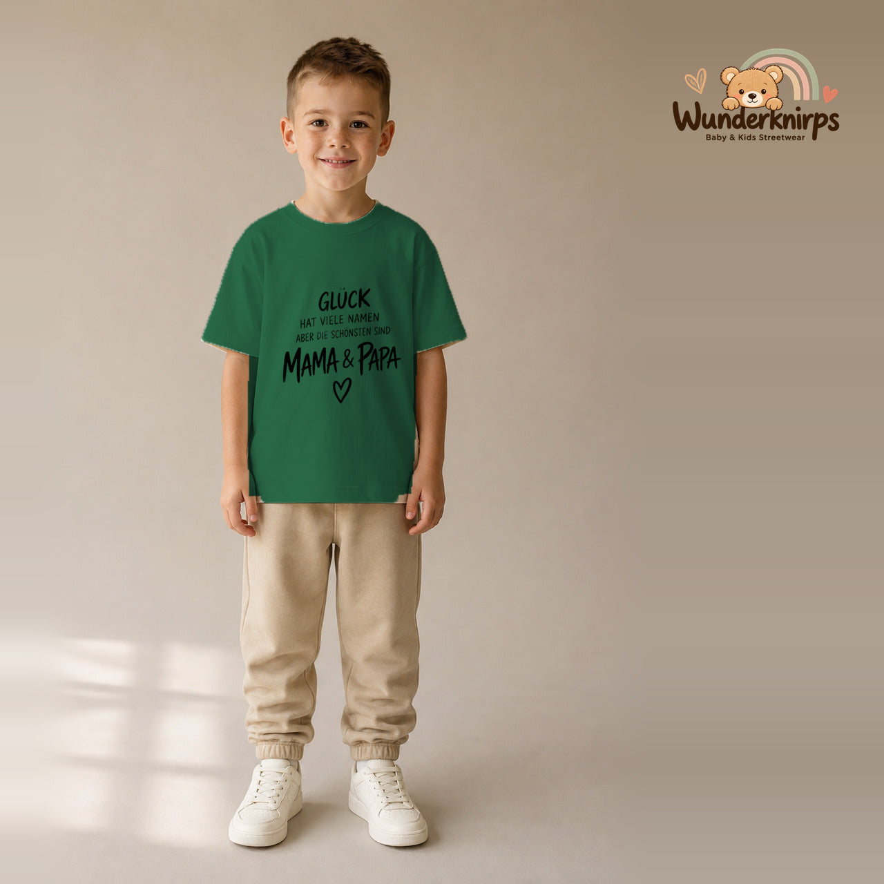 T-Shirt für Jungen in Grün mit Motiv „Glück Mama und Papa“, getragen von einem Kind – Wunderknirps.