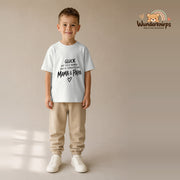 T-Shirt für Jungen in Weiß mit Motiv „Glück Mama und Papa“, getragen von einem Kind – Wunderknirps.