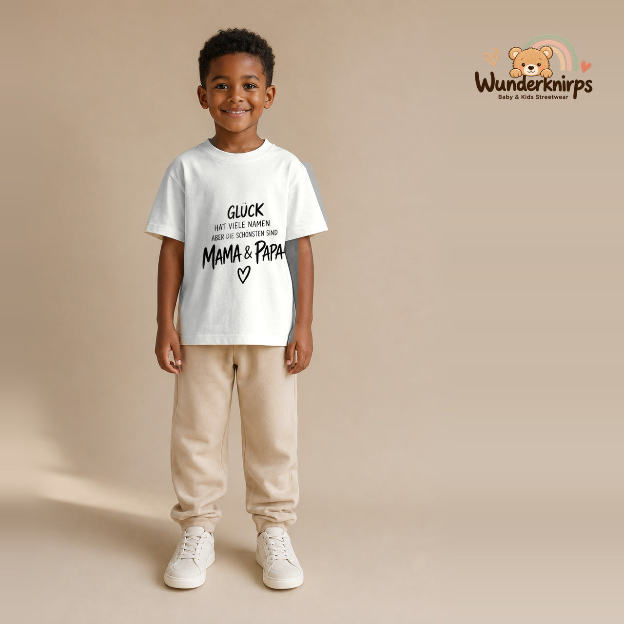 T-Shirt für Jungen in Weiß mit Motiv „Glück Mama und Papa“, getragen von einem Kind – Wunderknirps.