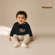 Babybody für Jungen in Schwarz mit Motiv „Good Kids Bad Rules“, getragen von einem Kind – Wunderknirps.