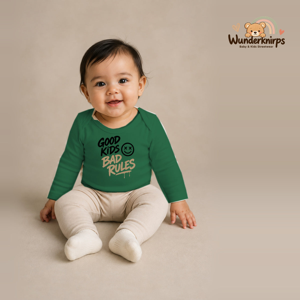 Babybody für Mädchen in Grün mit Motiv „Good Kids Bad Rules“, getragen von einem Kind – Wunderknirps.