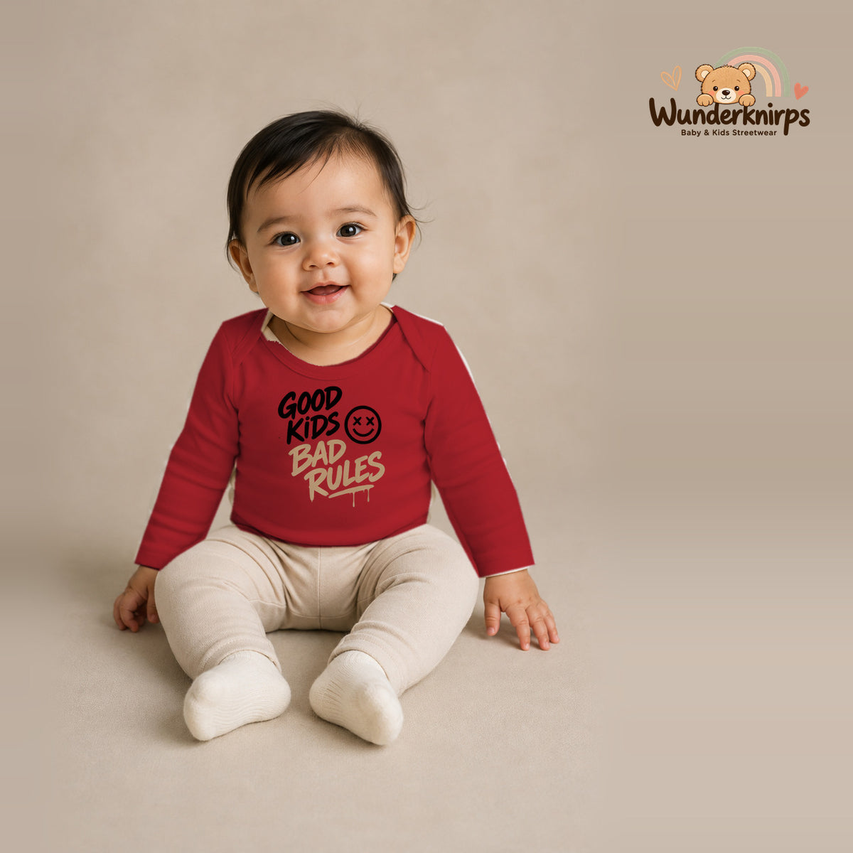 Babybody für Mädchen in Rot mit Motiv „Good Kids Bad Rules“, getragen von einem Kind – Wunderknirps.