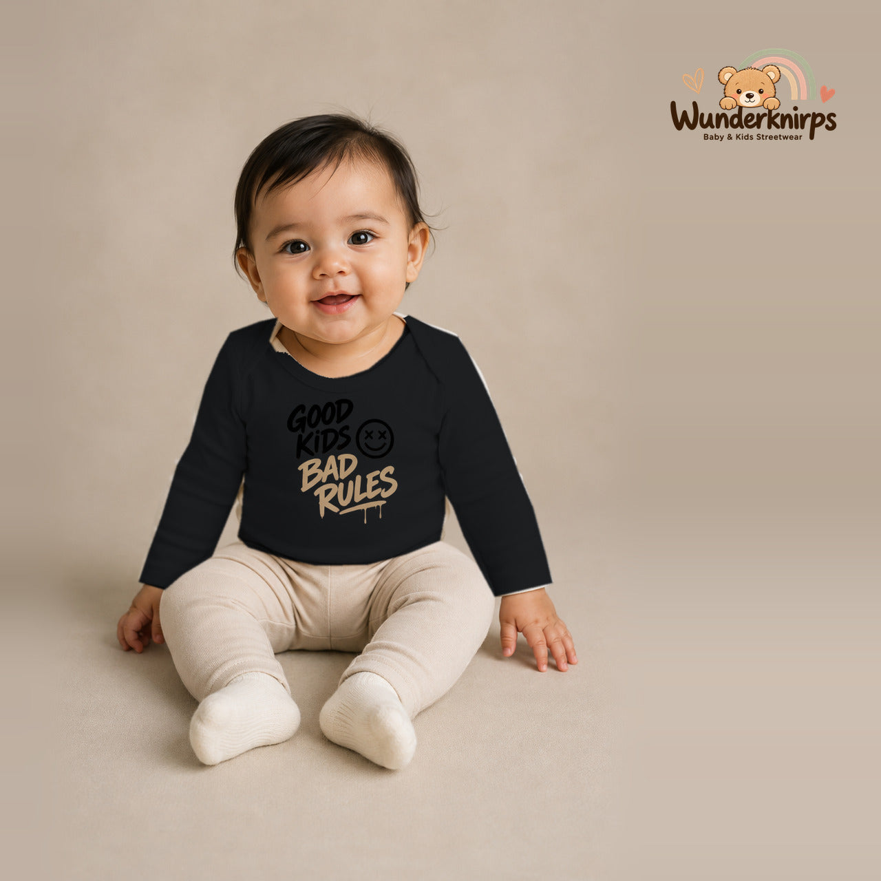 Babybody für Mädchen in Schwarz mit Motiv „Good Kids Bad Rules“, getragen von einem Kind – Wunderknirps.