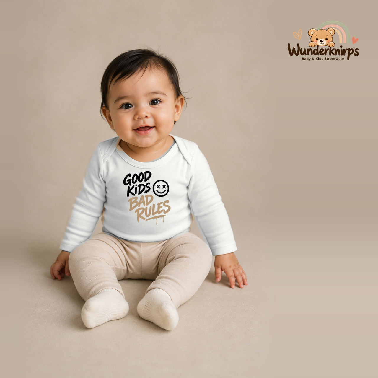 Babybody für Mädchen in Weiß mit Motiv „Good Kids Bad Rules“, getragen von einem Kind – Wunderknirps.