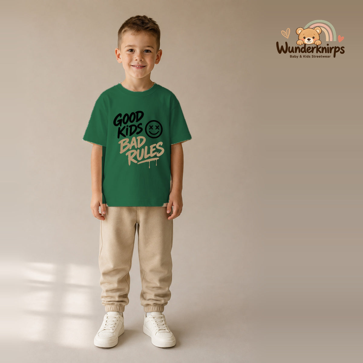 T-Shirt für Jungen in Grün mit Motiv „Good Kids Bad Rules“, getragen von einem Kind – Wunderknirps.