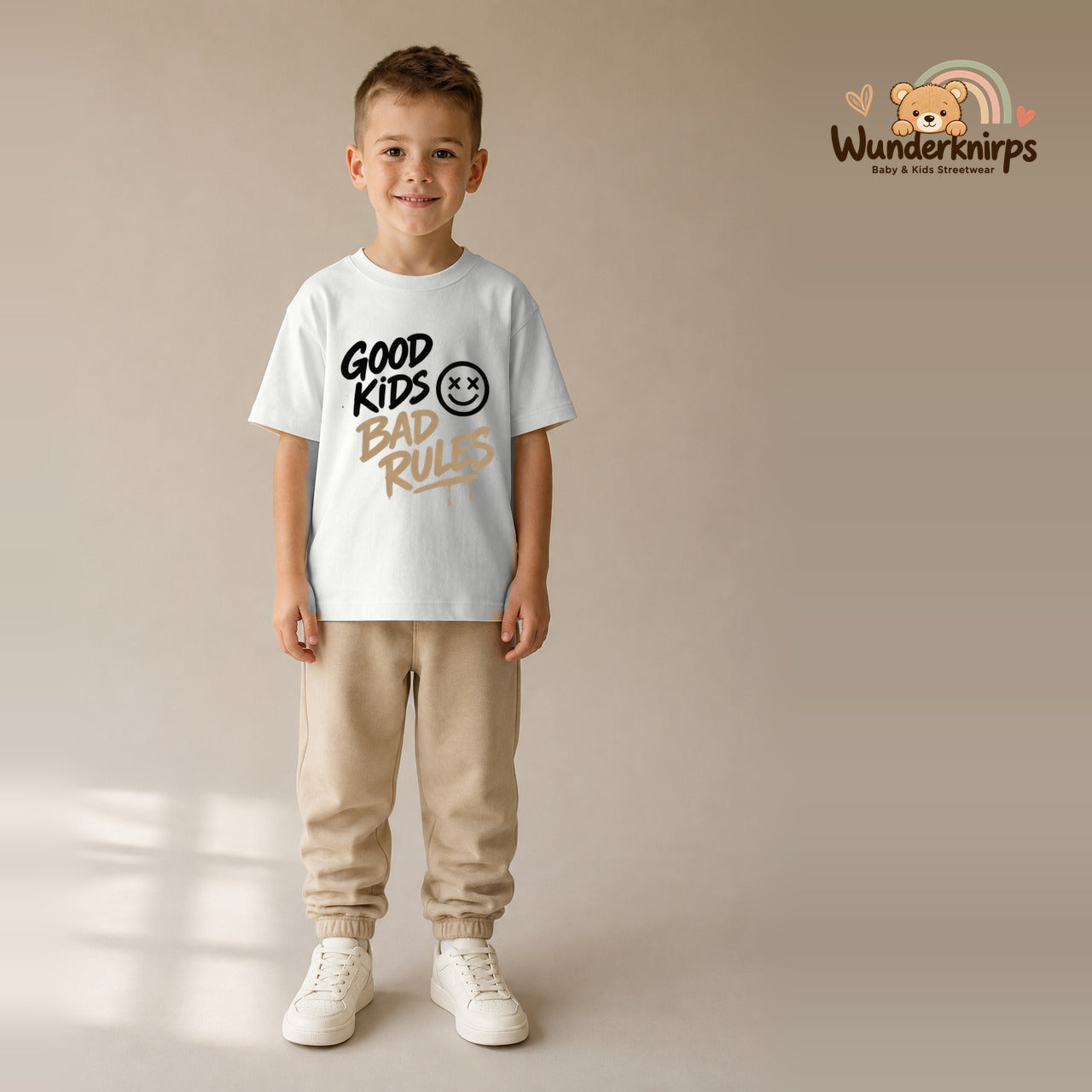 T-Shirt für Jungen in Weiß mit Motiv „Good Kids Bad Rules“, getragen von einem Kind – Wunderknirps.