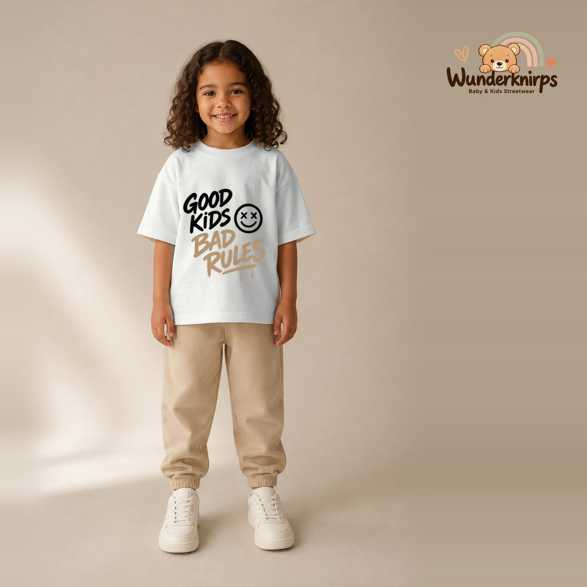 T-Shirt für Mädchen in Weiß mit Motiv „Good Kids Bad Rules“, getragen von einem Kind – Wunderknirps.