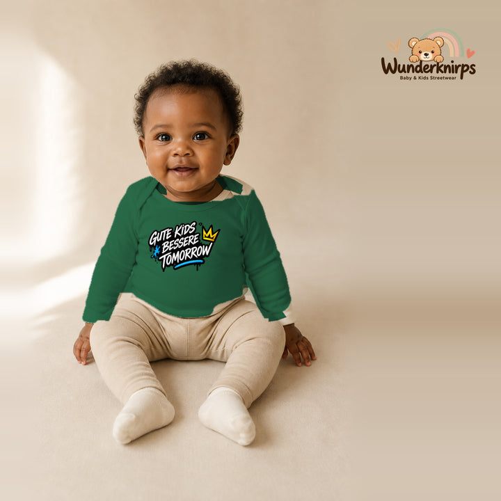 Babybody für Mädchen in Grün mit Motiv „Gute Kids“, getragen von einem Kind – Wunderknirps.