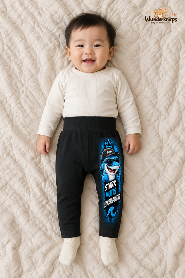 Hai Alltagsheld – Stark mutig einzigartig – Babyhose für Jungen: Schwarz mit Hai-Druck am Hosenbein – Wunderknirps.
