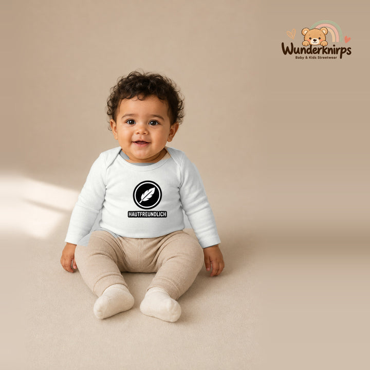 Babybody für Jungen in Weiß mit Motiv „Hautfreundlich“, getragen von einem Kind – Wunderknirps.