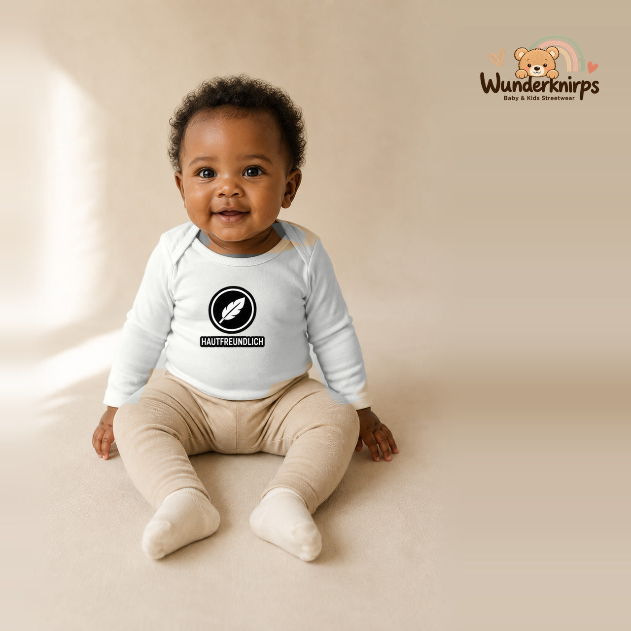 Babybody für Mädchen in Weiß mit Motiv „Hautfreundlich“, getragen von einem Kind – Wunderknirps.