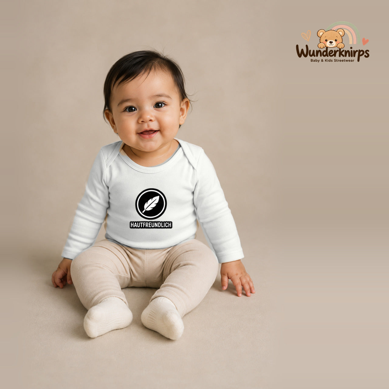 Babybody für Mädchen in Weiß mit Motiv „Hautfreundlich“, getragen von einem Kind – Wunderknirps.