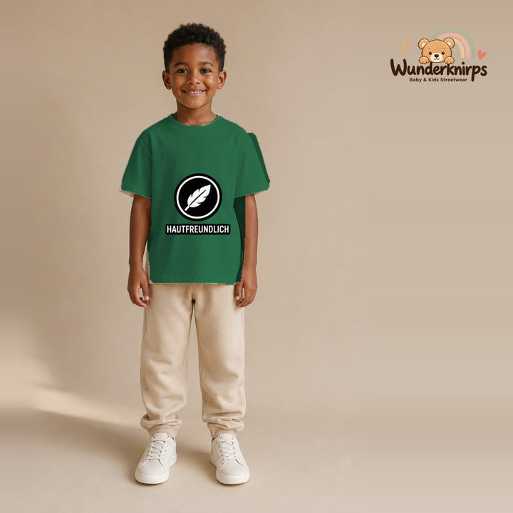 T-Shirt für Jungen in Grün mit Motiv „Hautfreundlich“, getragen von einem Kind – Wunderknirps.