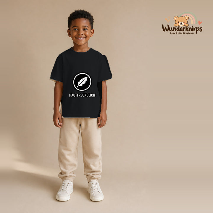 T-Shirt für Jungen in Schwarz mit Motiv „Hautfreundlich“, getragen von einem Kind – Wunderknirps.