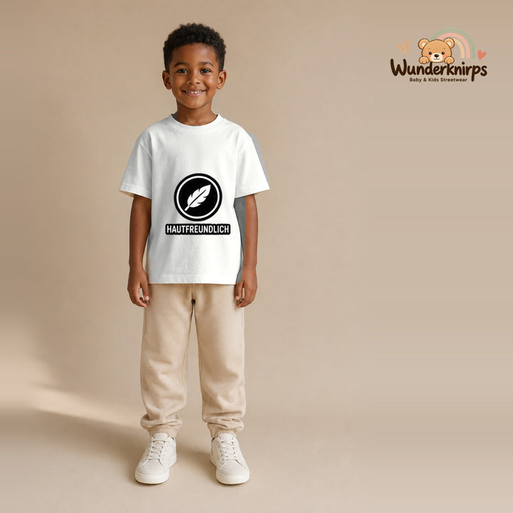 T-Shirt für Jungen in Weiß mit Motiv „Hautfreundlich“, getragen von einem Kind – Wunderknirps.