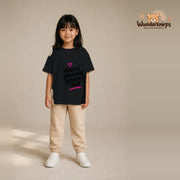 T-Shirt für Mädchen in Schwarz mit Motiv „Herzen brechen Regeln auch“, getragen von einem Kind – Wunderknirps.
