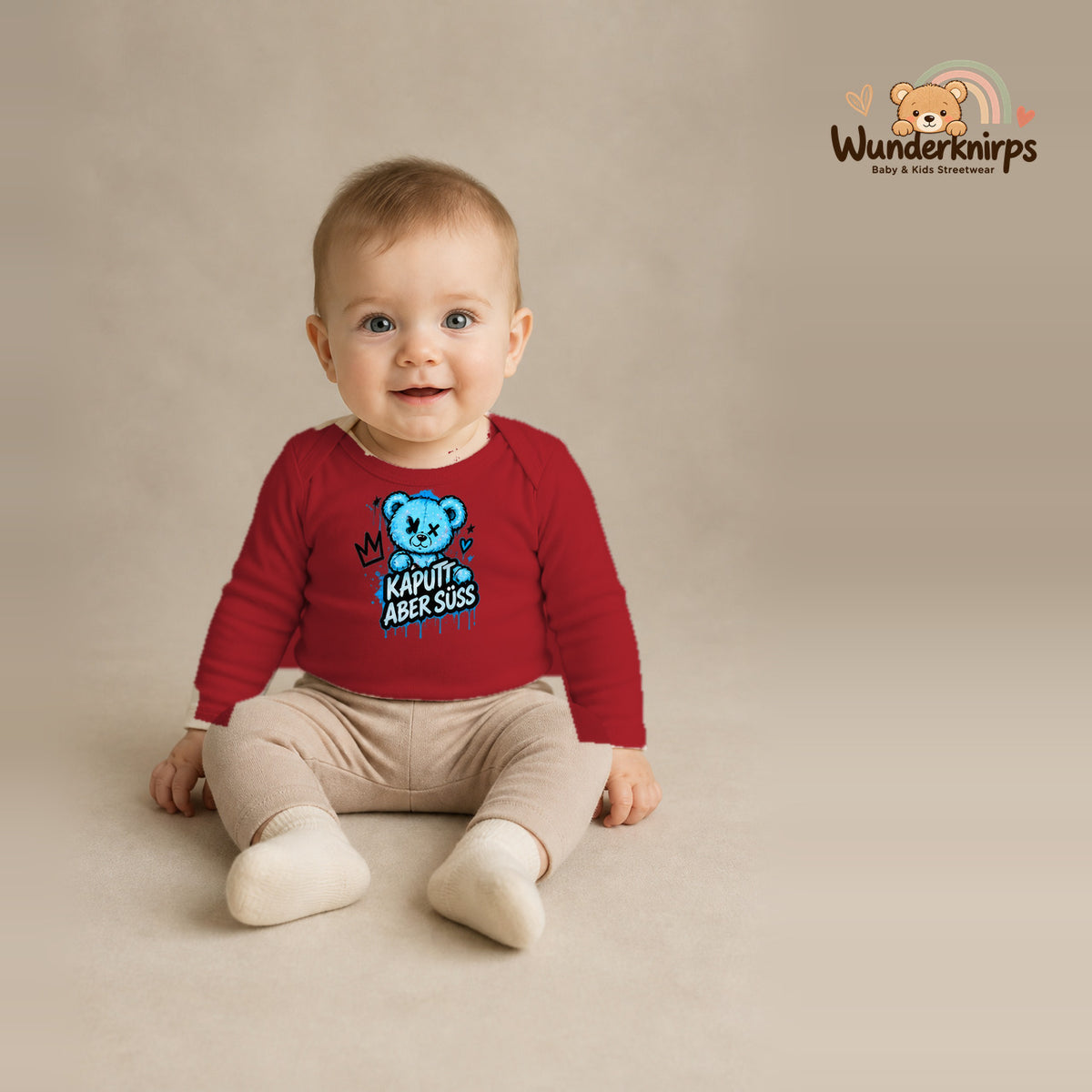 Babybody für Jungen in Rot mit Motiv „Kaputt aber süß“, getragen von einem Kind – Wunderknirps.