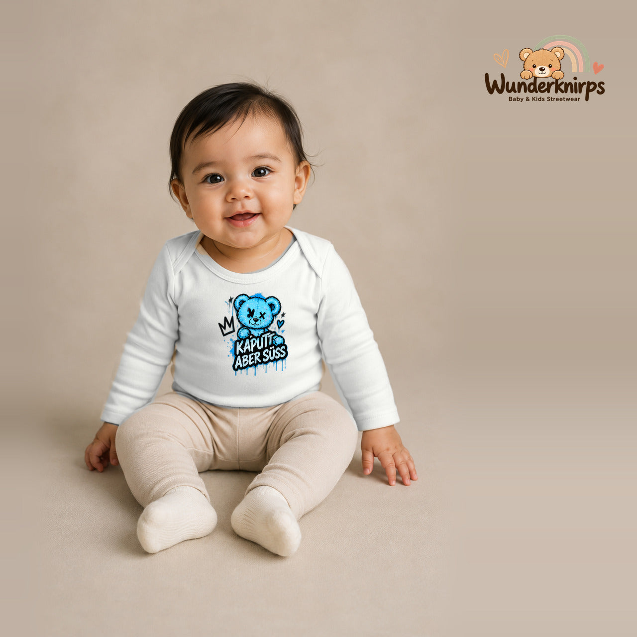 Babybody für Mädchen in Weiß mit Motiv „Kaputt aber süß“, getragen von einem Kind – Wunderknirps.