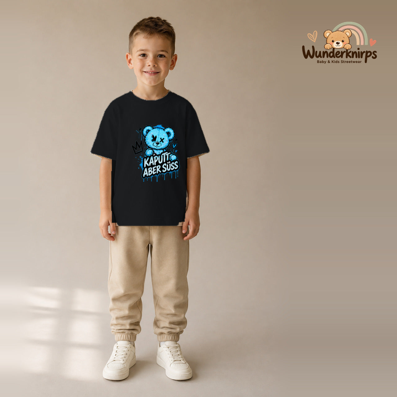 T-Shirt für Jungen in Schwarz mit Motiv „Kaputt aber süß“, getragen von einem Kind – Wunderknirps.