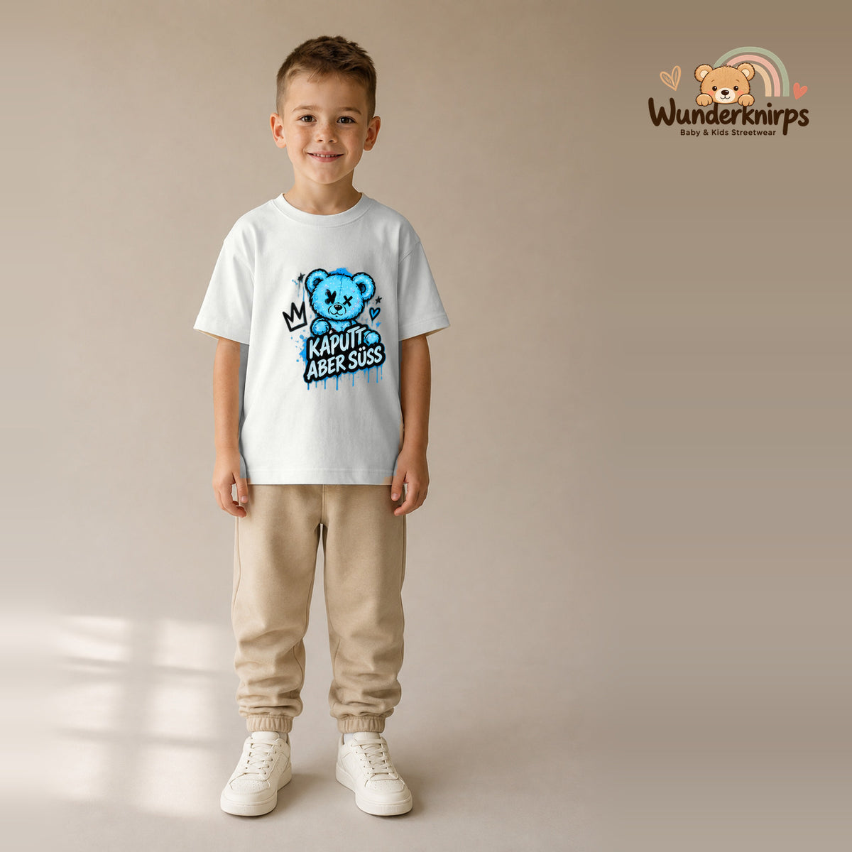 T-Shirt für Jungen in Weiß mit Motiv „Kaputt aber süß“, getragen von einem Kind – Wunderknirps.