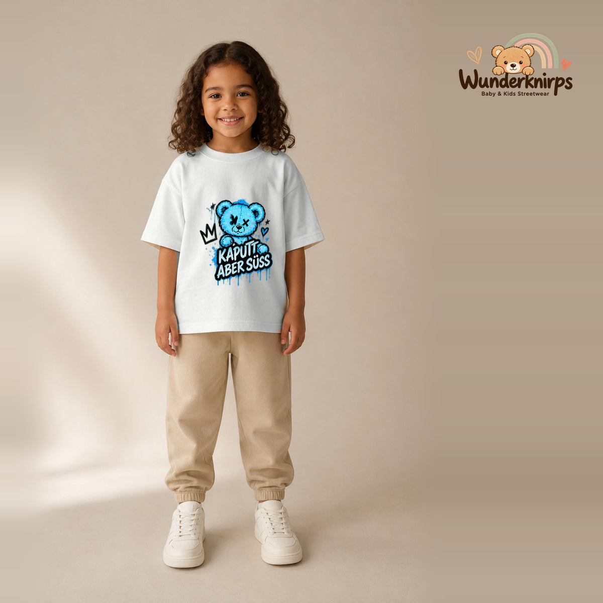 T-Shirt für Mädchen in Weiß mit Motiv „Kaputt aber süß“, getragen von einem Kind – Wunderknirps.