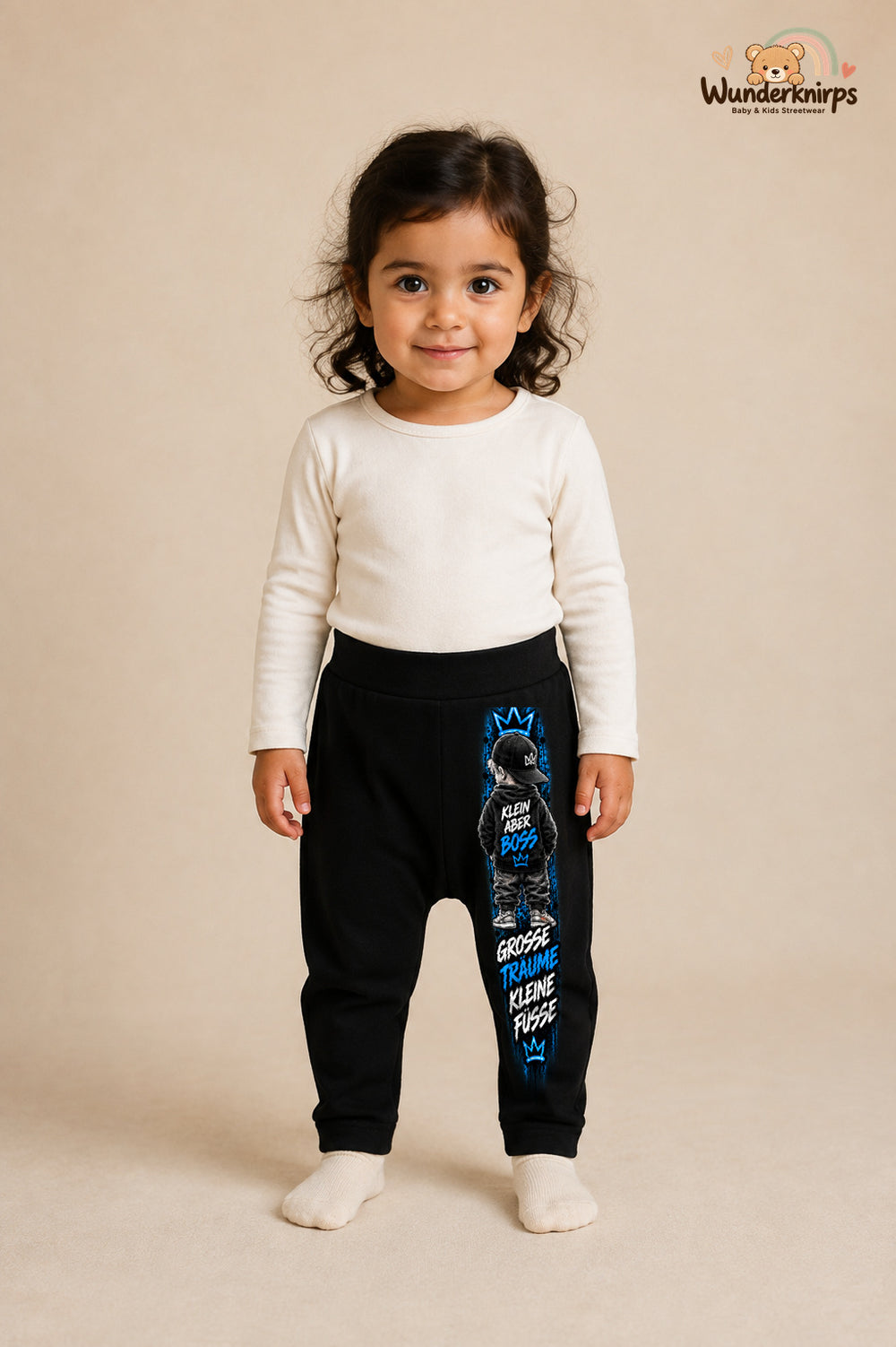 Große Träume kleine Füße – Kinderfigur mit Persönlichkeit – Babyhose für Mädchen: Schwarz mit Kinderfigur-Druck am Hosenbein – Wunderknirps.