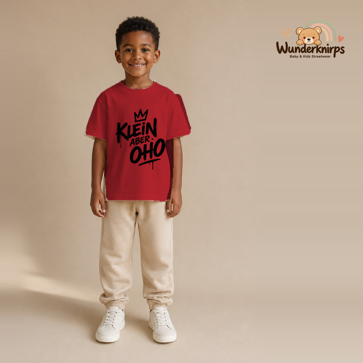 T-Shirt für Jungen in Rot mit Motiv „Klein aber oho“, getragen von einem Kind – Wunderknirps.