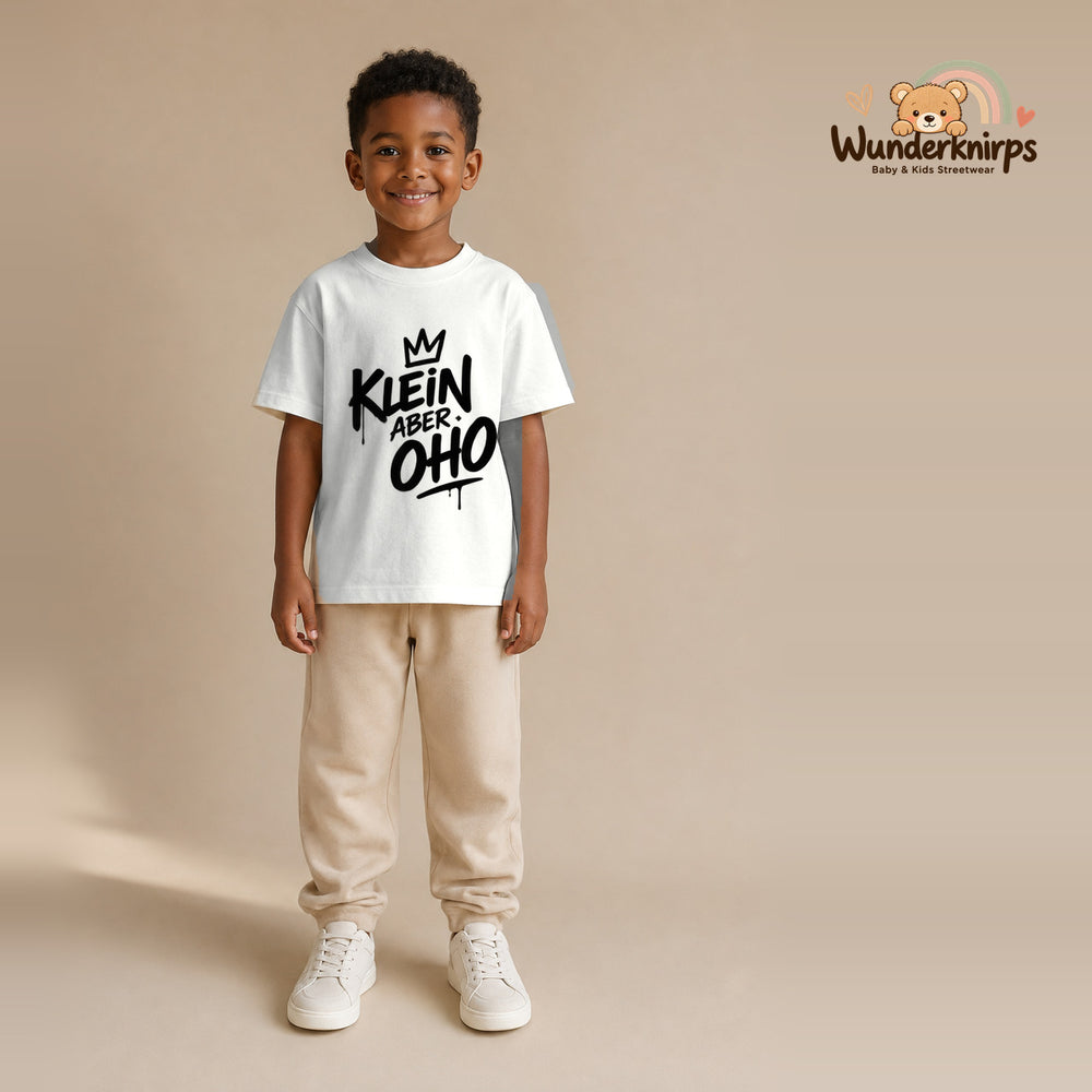 T-Shirt für Jungen in Weiß mit Motiv „Klein aber oho“, getragen von einem Kind – Wunderknirps.