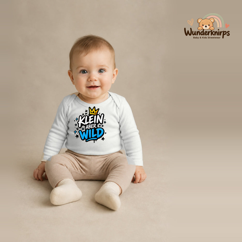 Babybody für Jungen in Weiß mit Motiv „Klein aber wild“, getragen von einem Kind – Wunderknirps.